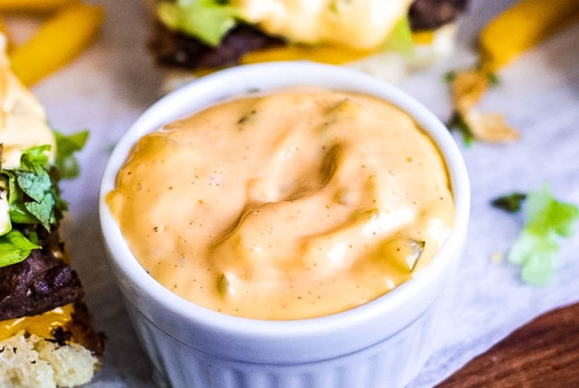 White ramekin filled with homemade copycat McDonald's special sauce with sliders in the background.