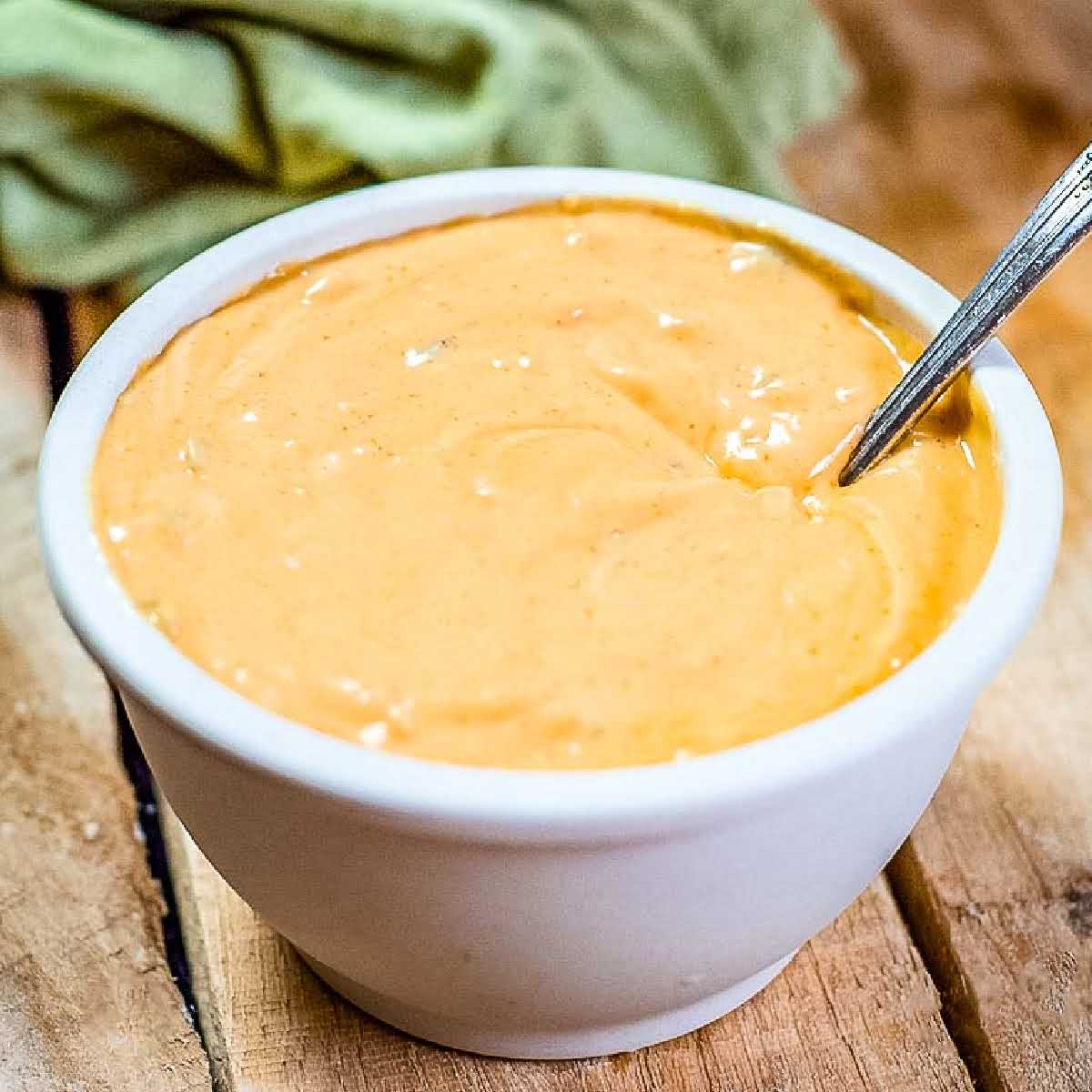 closeup view of homemade Big Mac sauce in a white ramekin with a spoon.