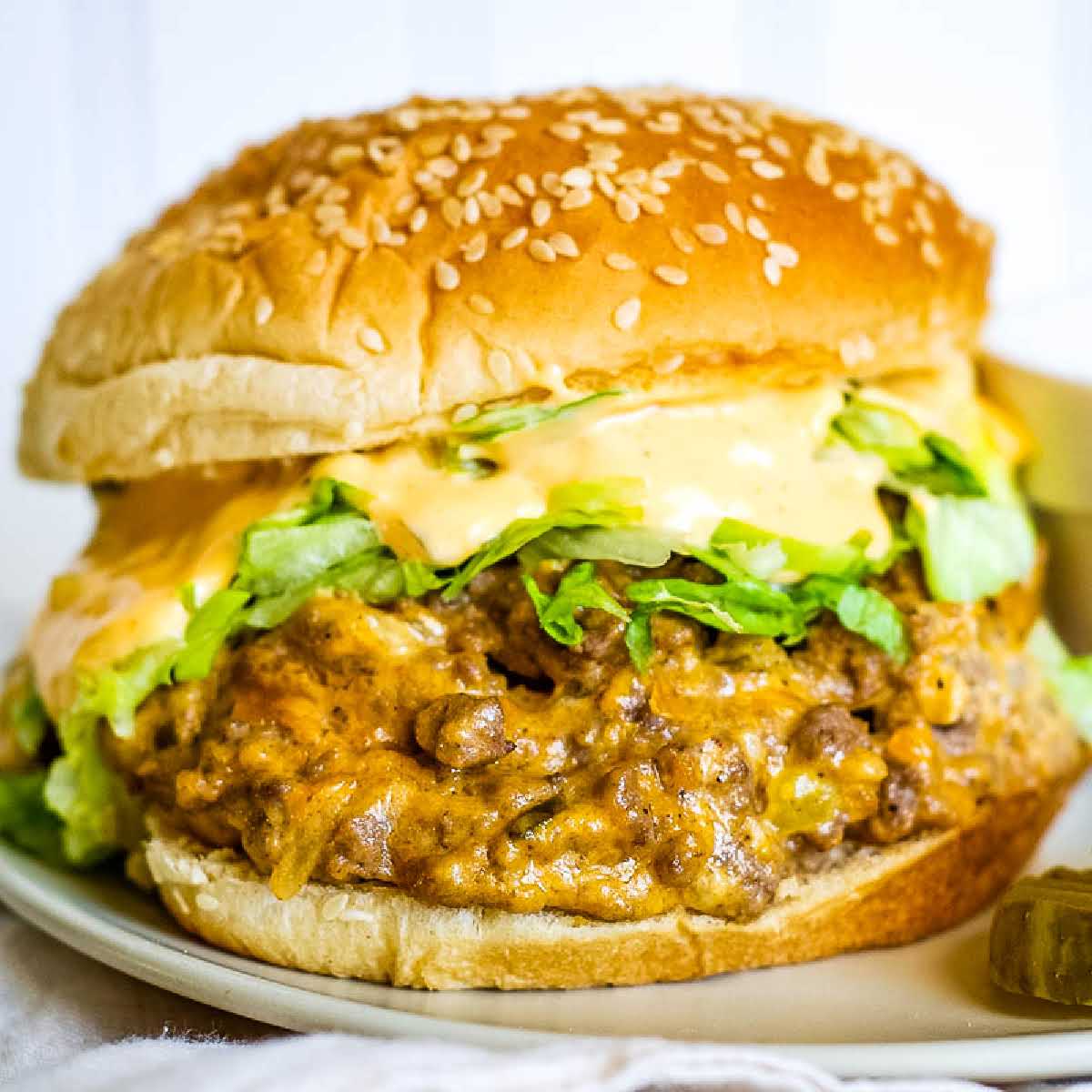 A Big Mac sloppy joe on a plate topped with lettuce and secret sauce.