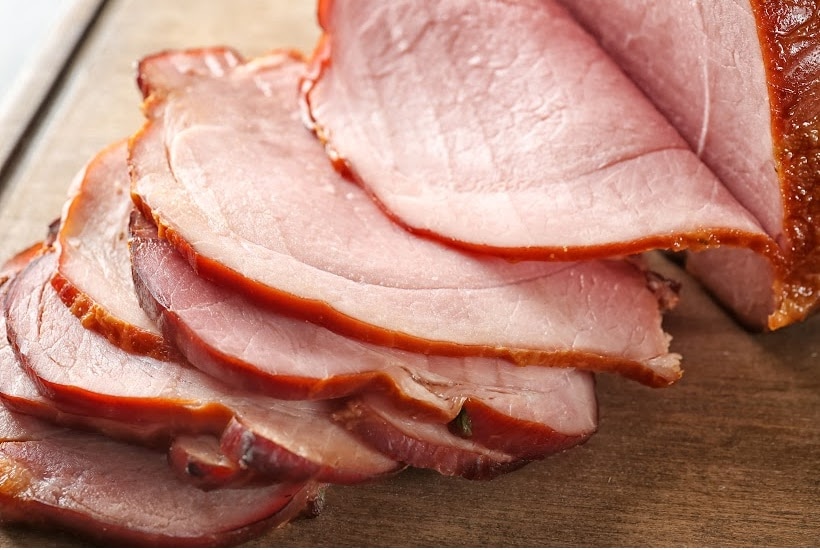 ham slices on a wooden cutting board.