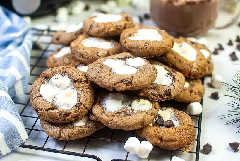 hot chocolate cookies with marshmallows on a wire cooling rack.