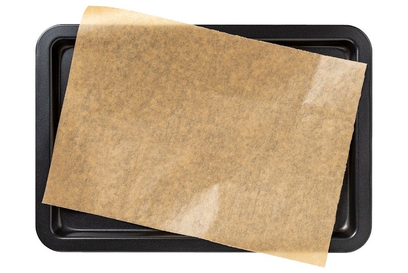 metal air fryer tray with a sheet of parchment paper.