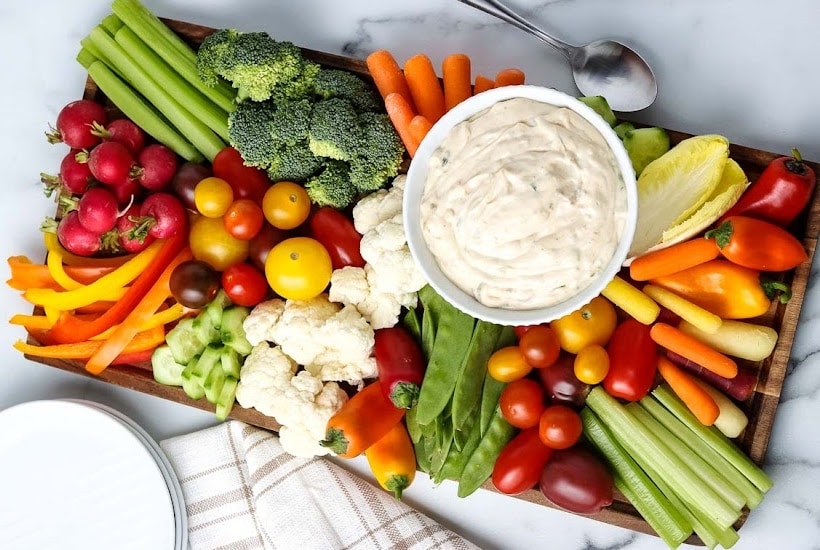 fresh vegetable platter with a bowl of creamy dip.
