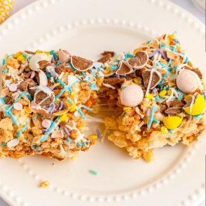 closeup of two mini egg Rice Krispie squares on a white plate.