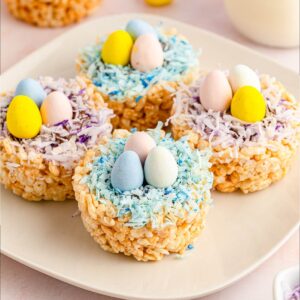 closeup view of four Rice Krispie Easter nests on a white plate.