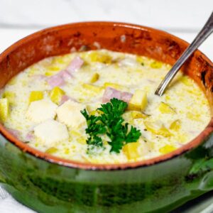 Front view of Slow Cooker Ham and Potato Soup in a soup bowl with a spoon.