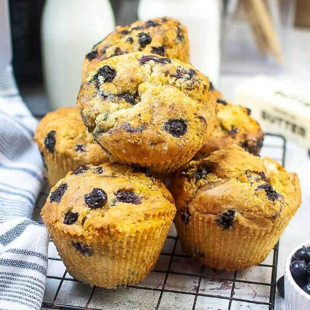 Air fried blueberry muffins stacked on a wire rack.