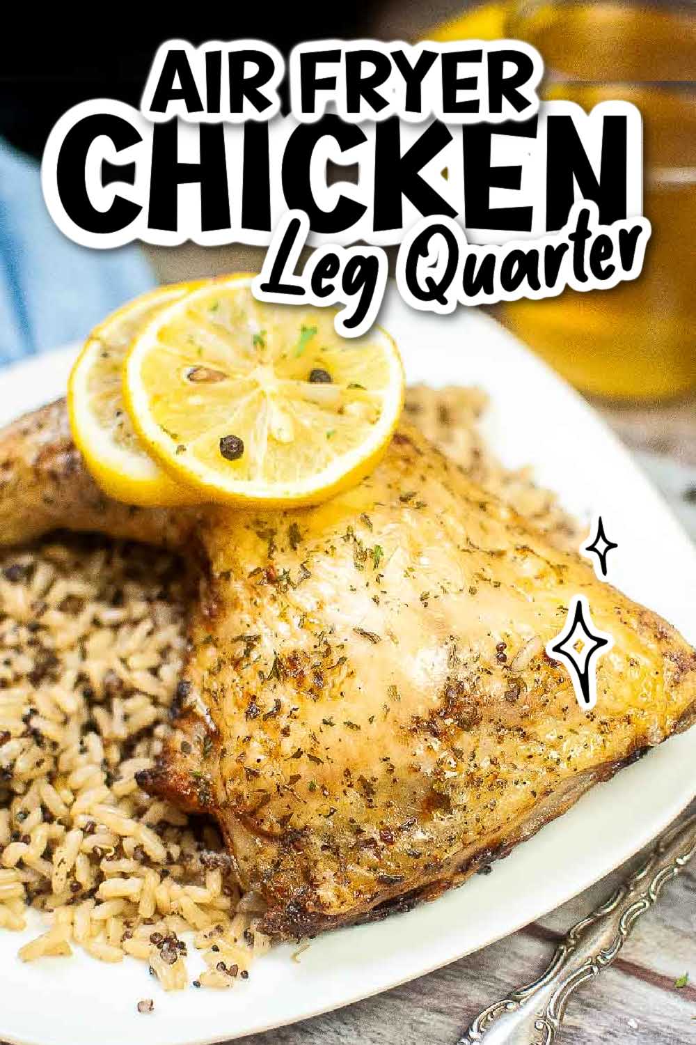 Air fryer chicken leg quarter topped with a lemon slice on a white plate with rice with text overlay.