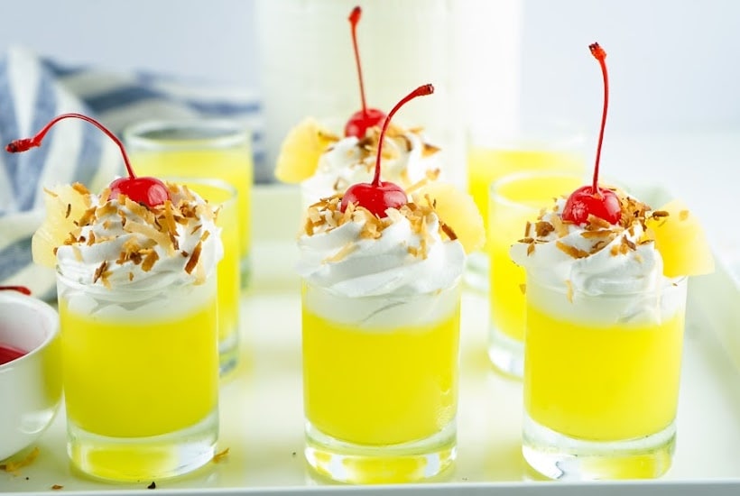 Front view of garnished Pina Colada Jello Shots on a white tray.