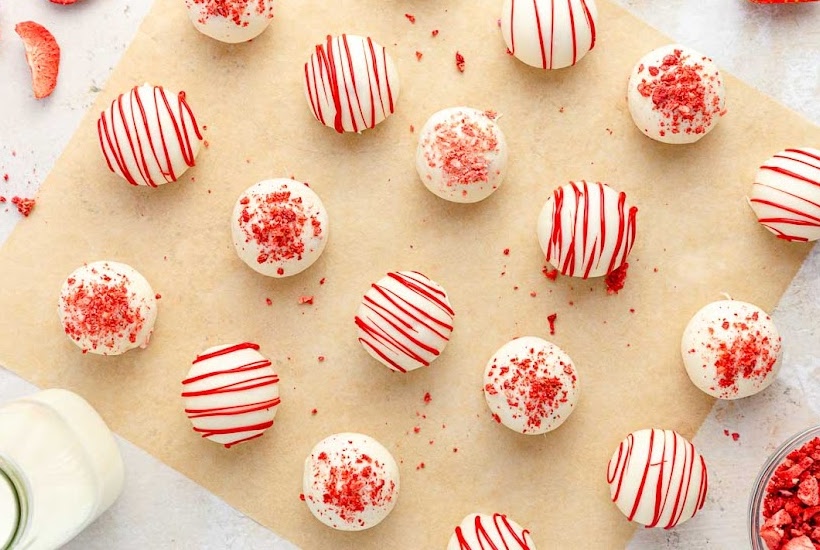Overhead view of Strawberry Cake pops truffles on parchment paper.