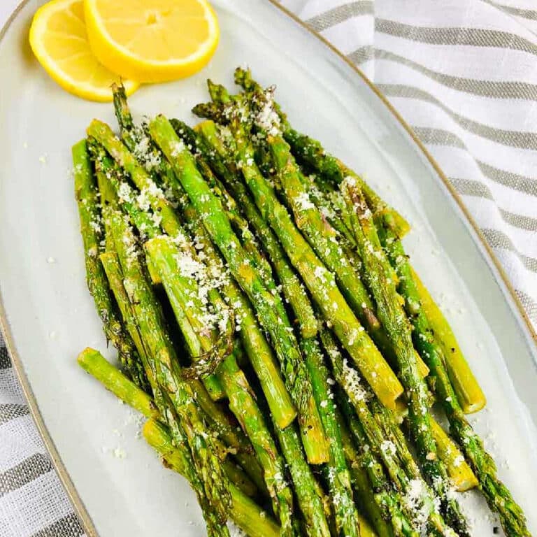 Air fried asparagus garnished with parmesan and lemon slices with text overlay.