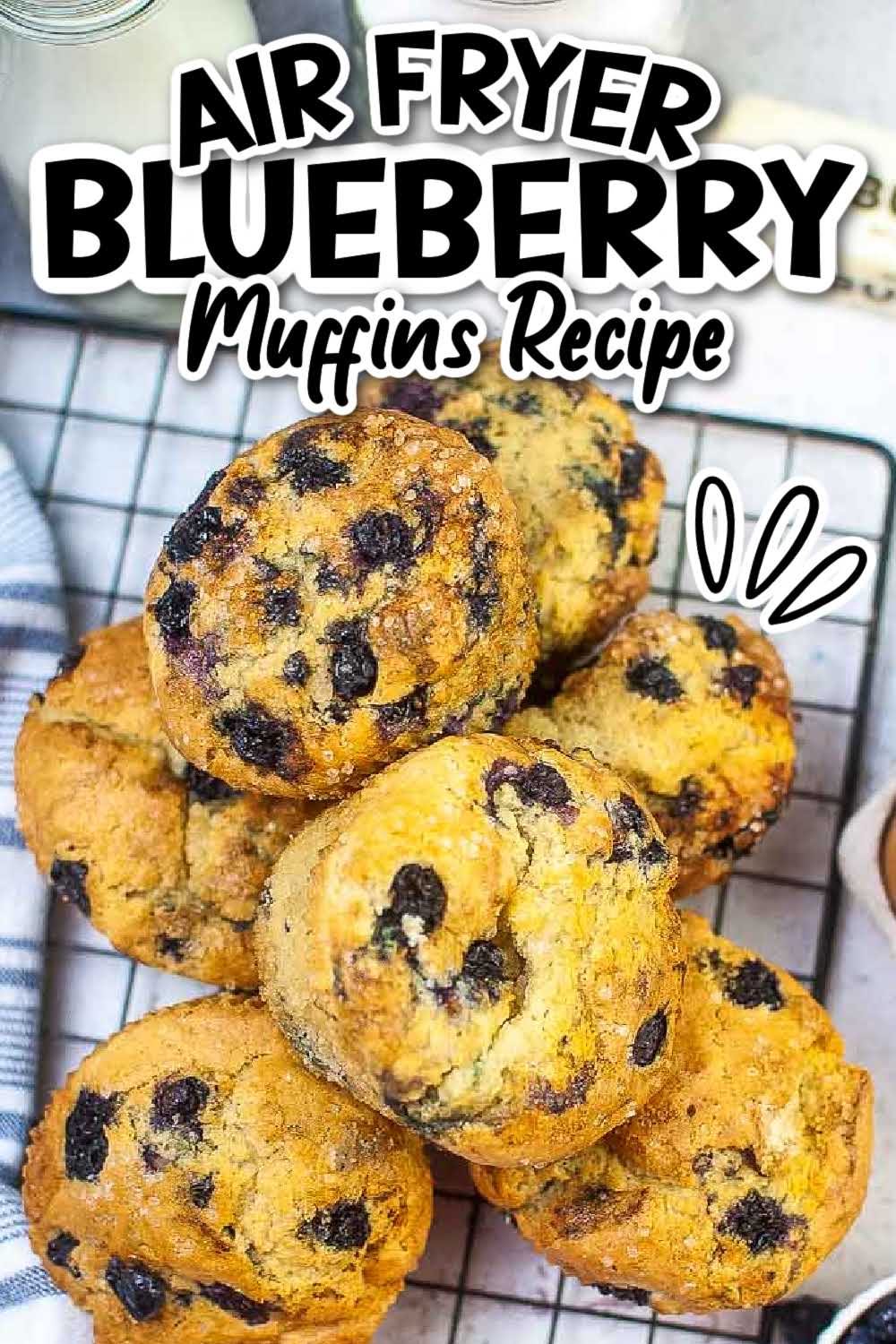 Top view of air fryer blueberry muffins stacked on a wire cooling rack with text overlay.