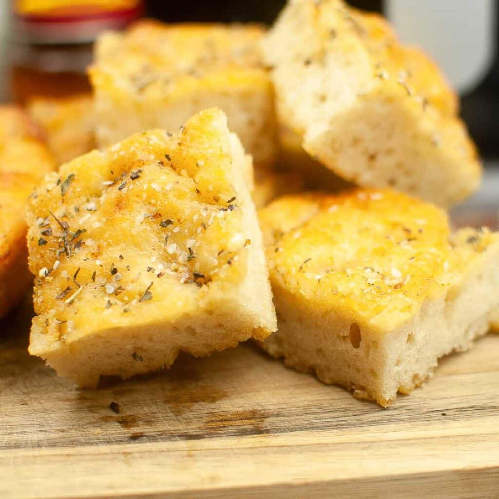 Front close up of air fryer Focaccia bread cut into squares and stacked on a cutting board.
