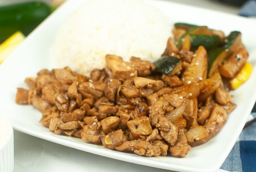 Air fried chicken hibachi chicken with vegetables on a white plate with white rice.