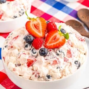 Front close up of Red White and Blue Cheesecake Salad topped with fresh berries.