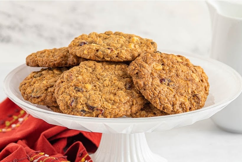 A white platter filled with of Oatmeal Cookies with dried cranberries and white chocolate chips.