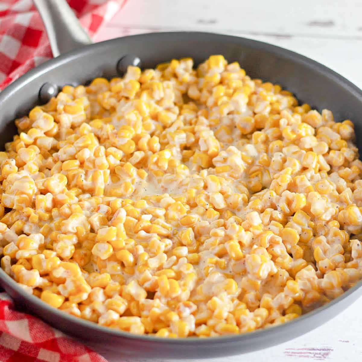 Close up view of homemade creamed corn in a skillet.