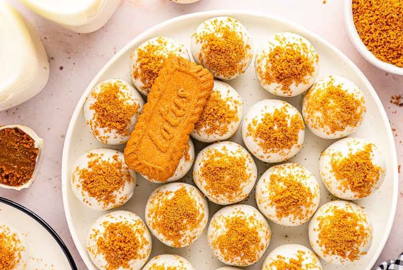 Overhead view of Biscoff Truffles on a white plate with a Lotus cookie wafer on top.