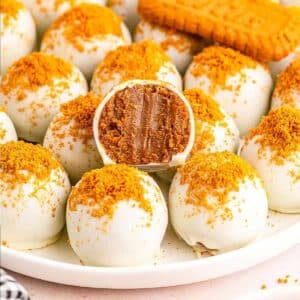 Close up of Biscoff Truffles on a plate with a bite taken from one.