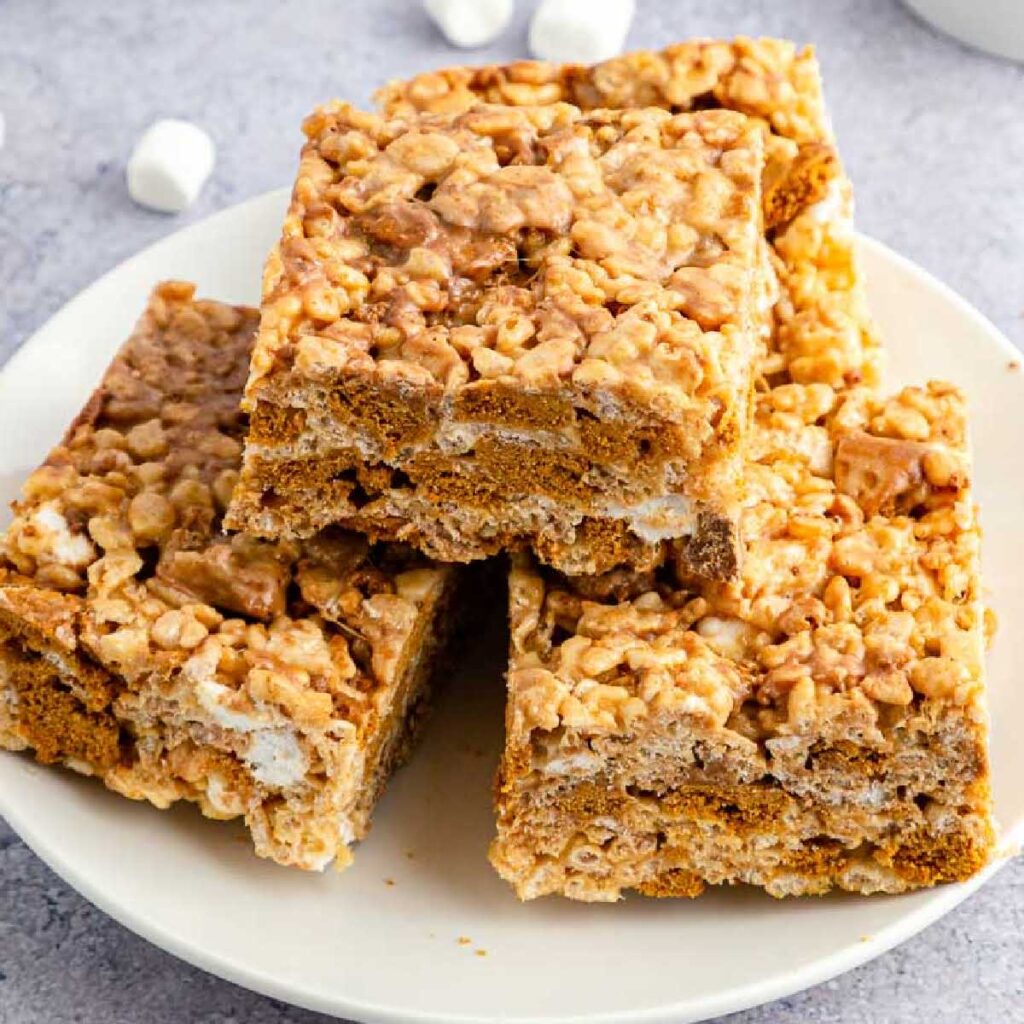 A plate of Biscoff Cookie Butter Rice Krispie Treats stacked on each other.