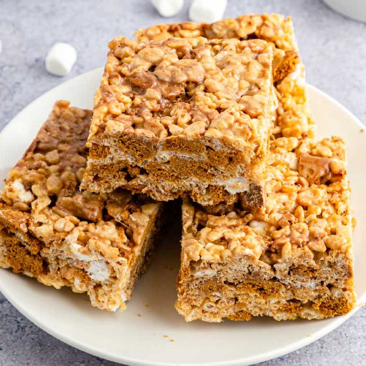 A white plate filled with a stack of Biscoff Cookie Butter Rice Krispie Treats.