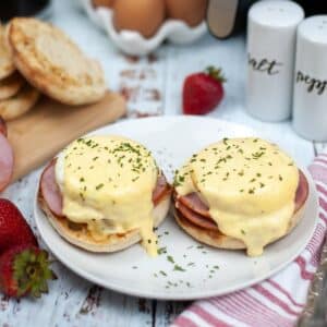 Two air fryer eggs Benedict garnished with parsley on a white plate.