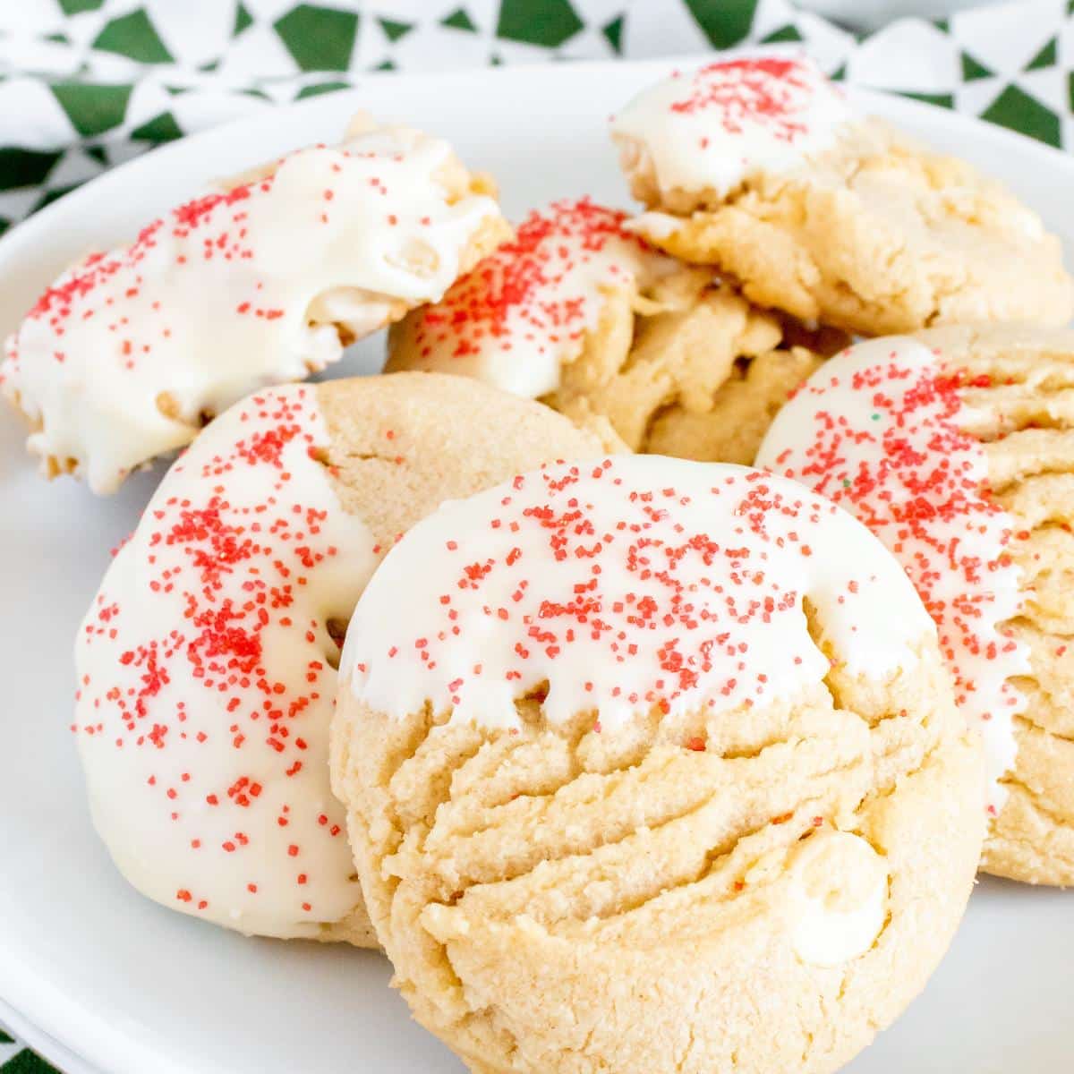 A white plate filled with white chocolate peanut butter cookies decorated with red sprinkles.