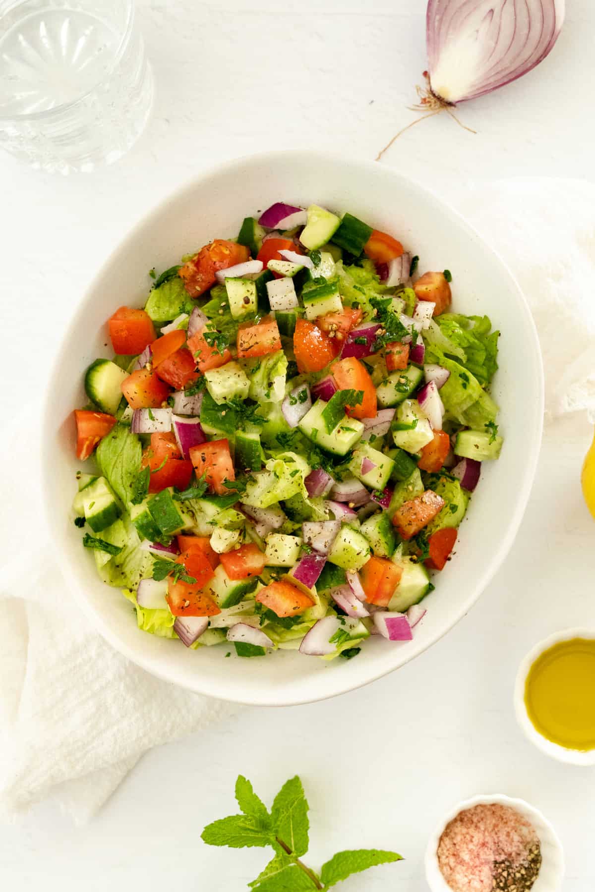 A simple salad of lettuce, tomato and cucumber tossed in an oil based dressing.