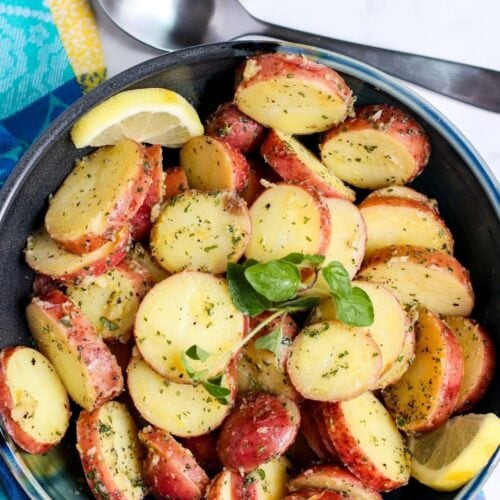 Greek-style potato salad with an oil-based dressing in a blue serving bowl.