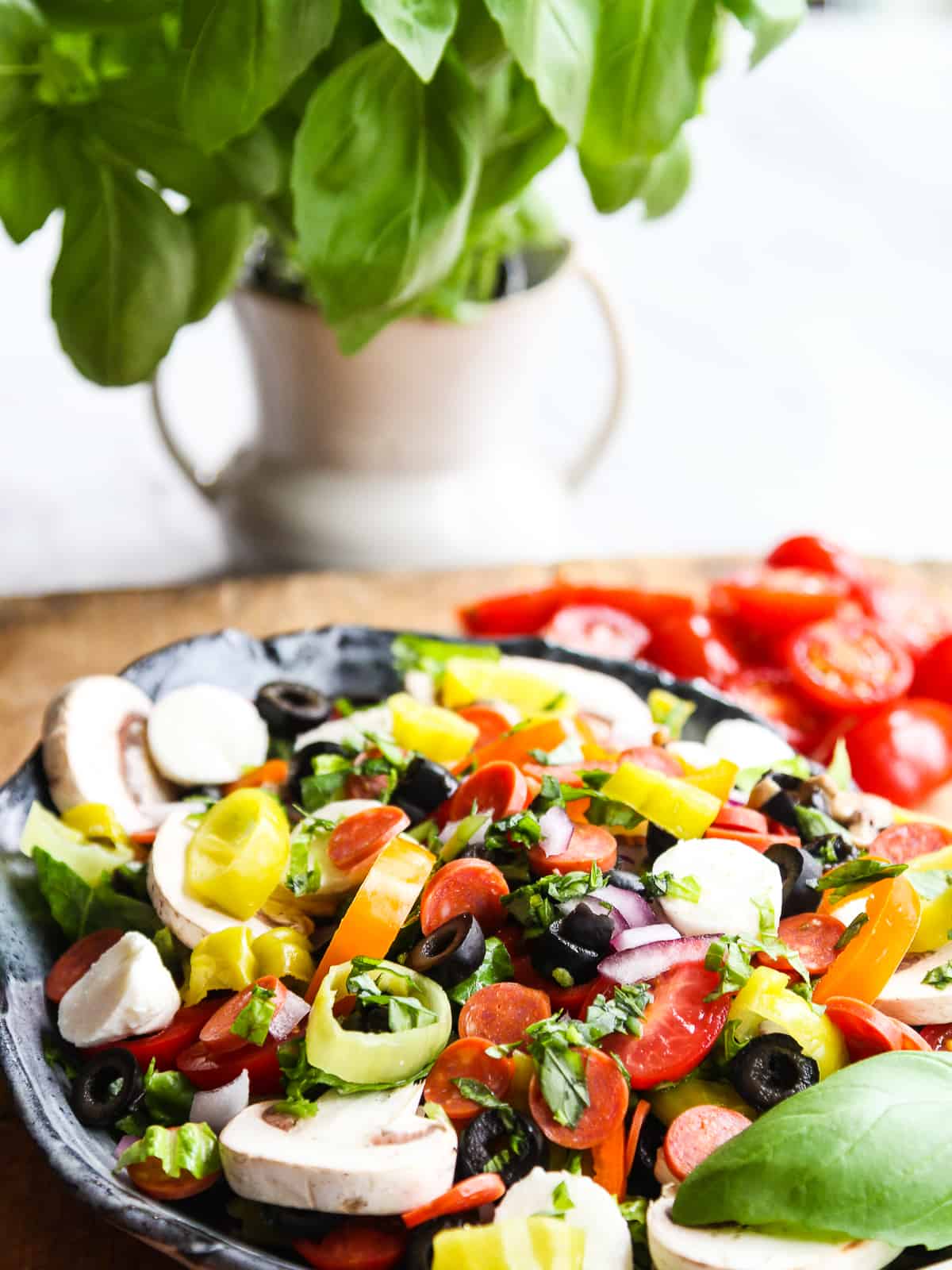 A bowl of salad with pizza toppings.