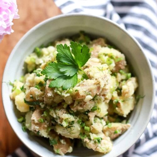 Vegan potato salad with salt and vinegar dressing in a white serving bowl.