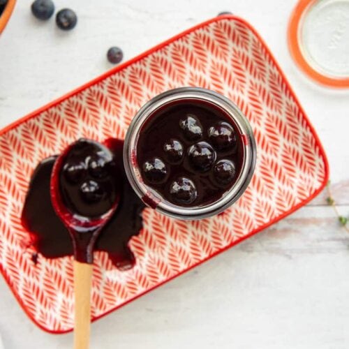 Blueberry balsamic bbq sauce in a jar with a spoonful on the side.