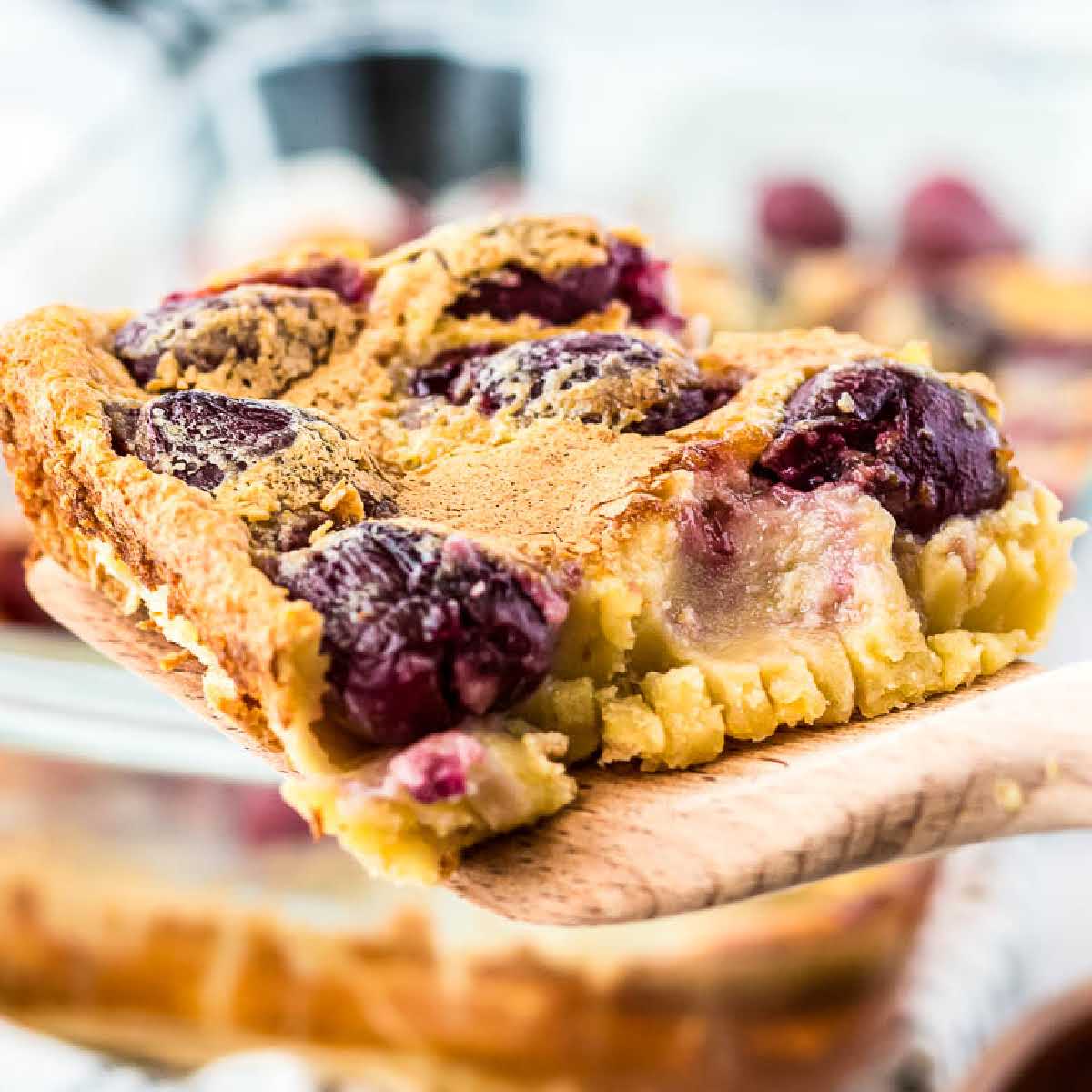 Closeup view of a slice of cherry clafouti on a spatula.