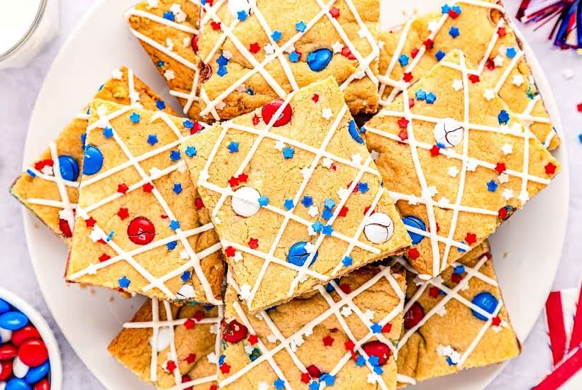 Slices of M&M cookie bars on a white plate.