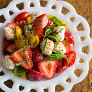 White bowl filled with strawberry caprese salad.
