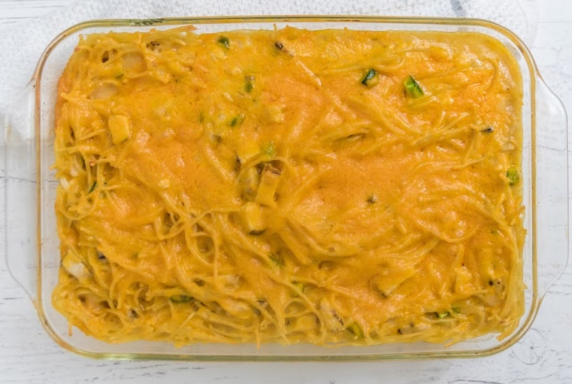 Glass casserole dish of cheesy chicken spaghetti.