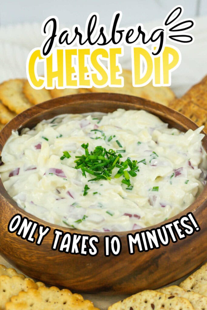 Closeup view of copycat Jarlsberg cheese dip in a wooden bowl with crackers and text overlay.