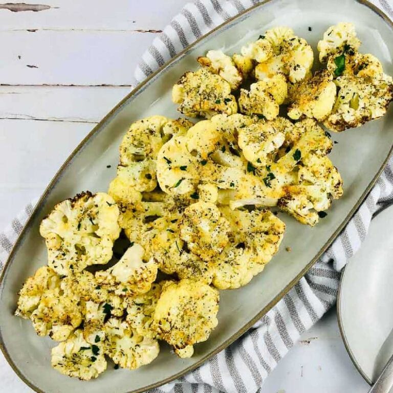 Air fried cauliflower steaks on a serving platter.