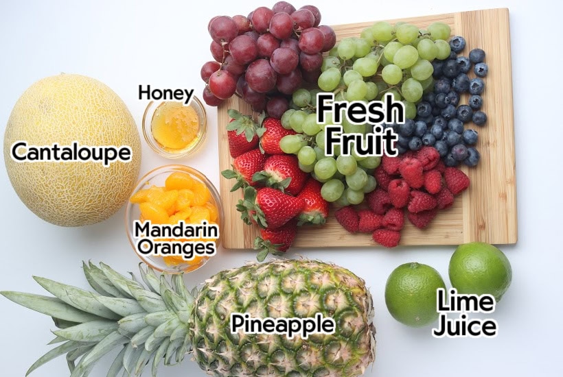 Ingredients to make fresh fruit salad with honey lime dressing with text labels.