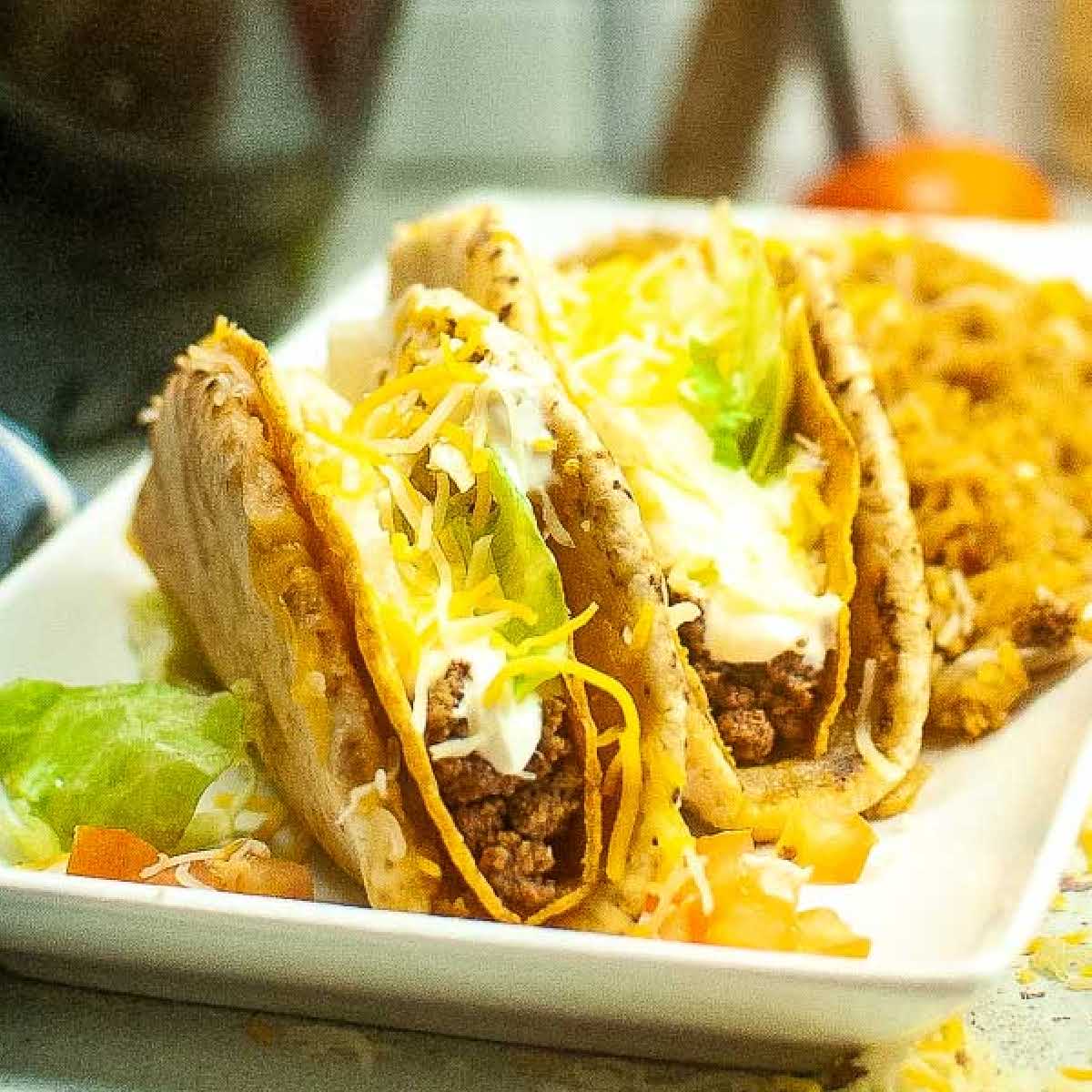 Two homemade air fryer cheesy gordita crunch on a white plate.
