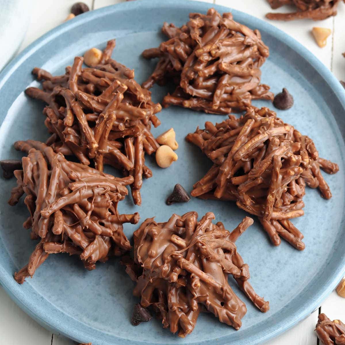 No bake chocolate peanut butter haystack cookies with chow mein noodles on a blue plate.