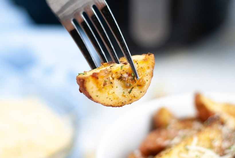 Close up of one roasted red potato on a fork.