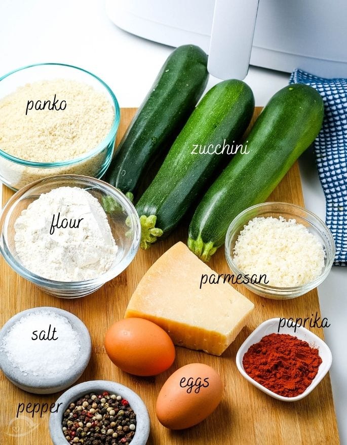 Ingredients to make crispy breaded air fryer zucchini chips with text labels.