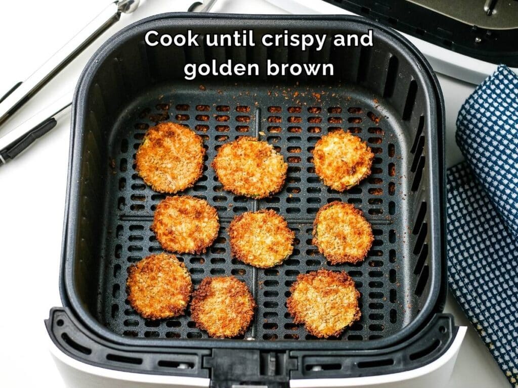 Cooked breaded zucchini rounds in an air fryer basket with text overlay.