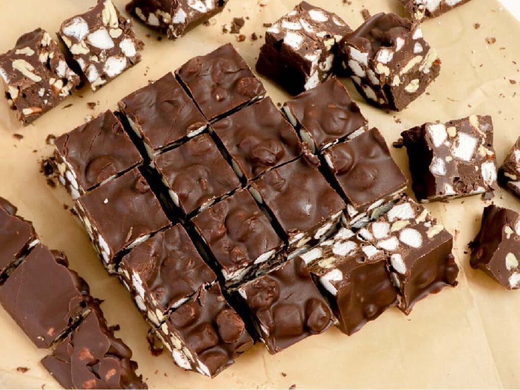 Rocky road candies cut into squares on parchment paper.