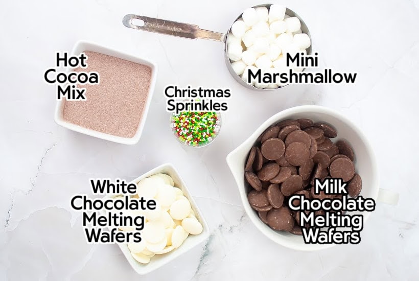 Ingredients to make holiday hot cocoa bombs with text labels.