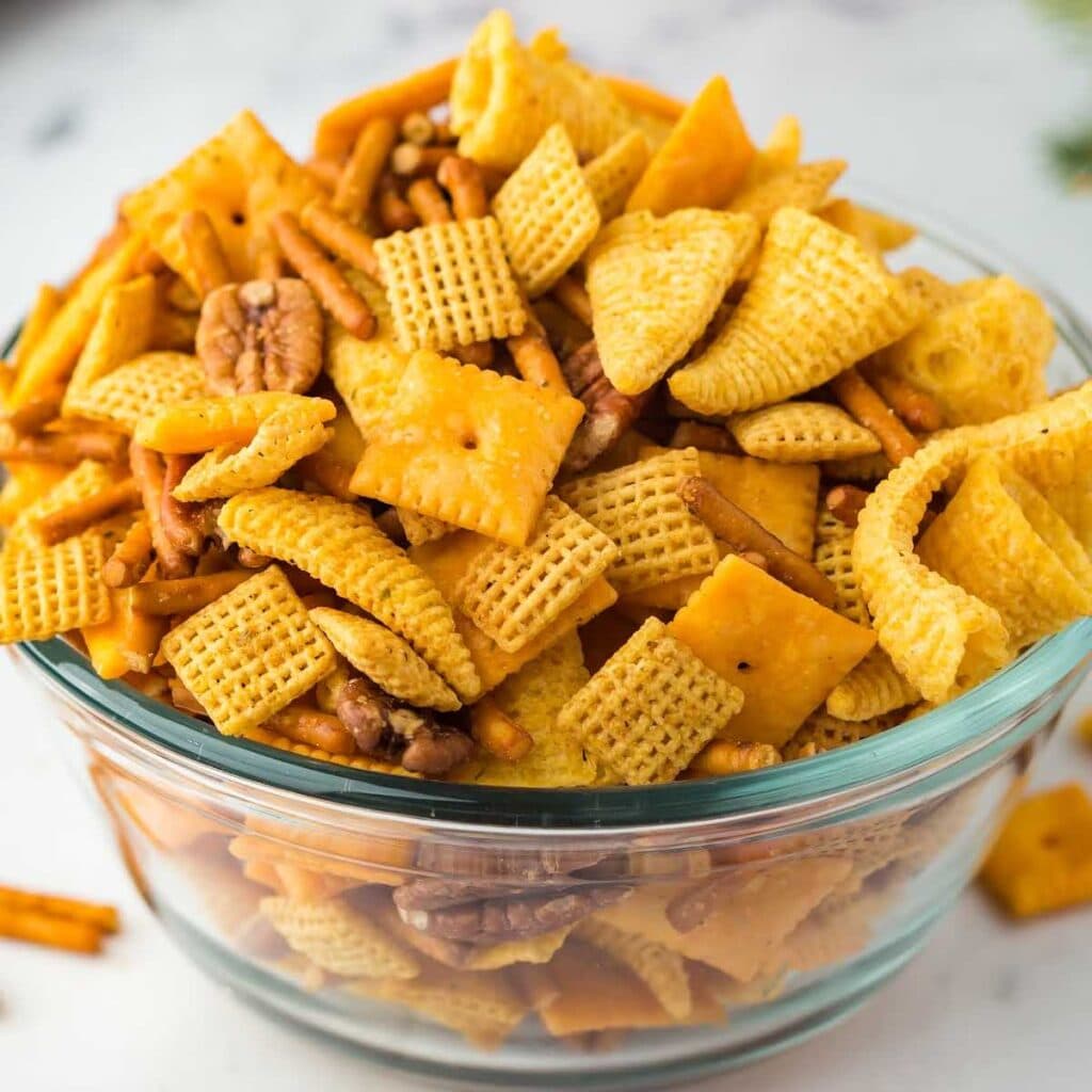 Clear glass bowl filled with sweet and spicy party mix recipe.