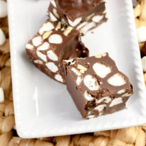Three pieces of homemade rocky road candy on a white plate.