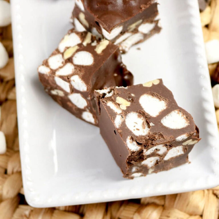 Three pieces of homemade rocky road candy on a white plate.