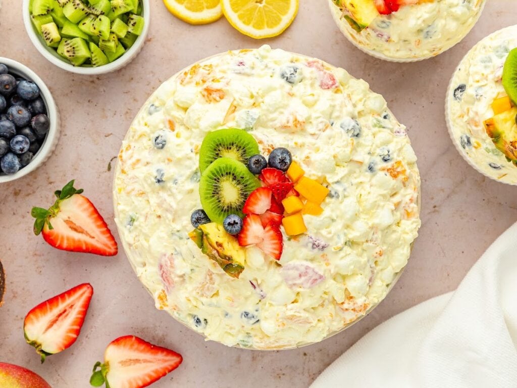 Top view of Hawaiian fruit salad in a large bowl with fresh fruit on top as a garnish.